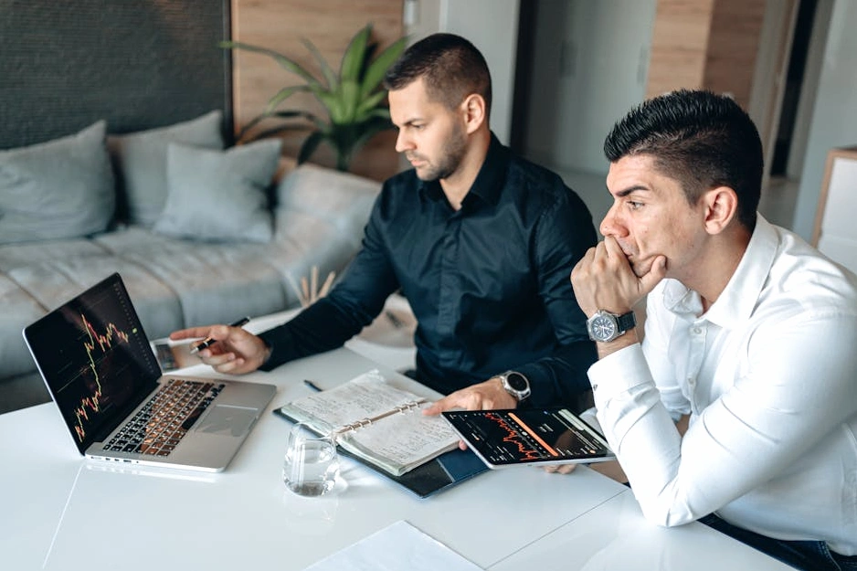 Tým konzultantů analyzuje finanční grafy v moderní kanceláři.